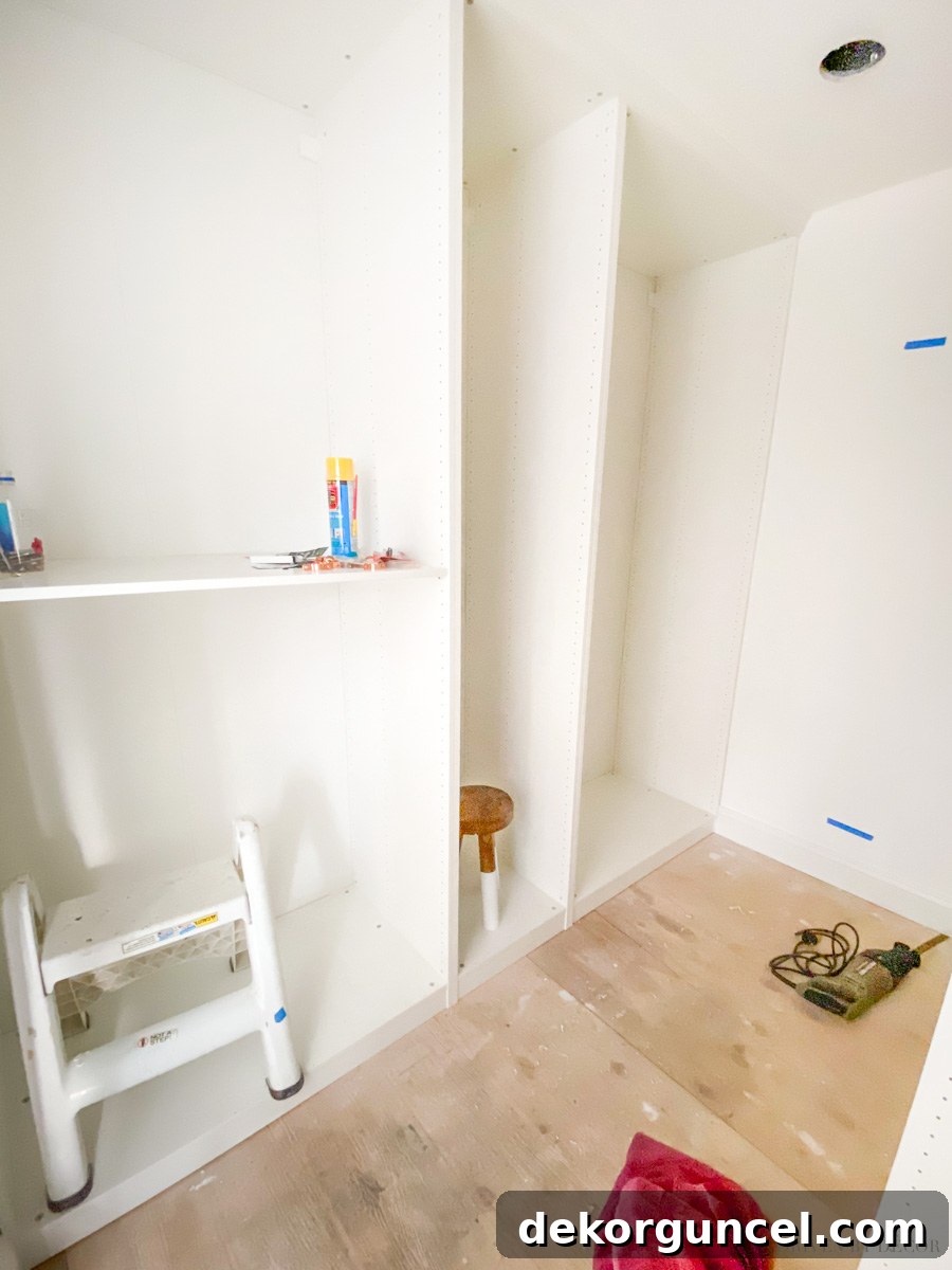 Initial installation of IKEA PAX wardrobe frames within a new walk-in closet, demonstrating the modular setup.