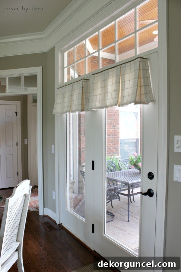 Tailored valances gracefully hung over French doors, connecting the kitchen to the patio, offering style without obstructing access.