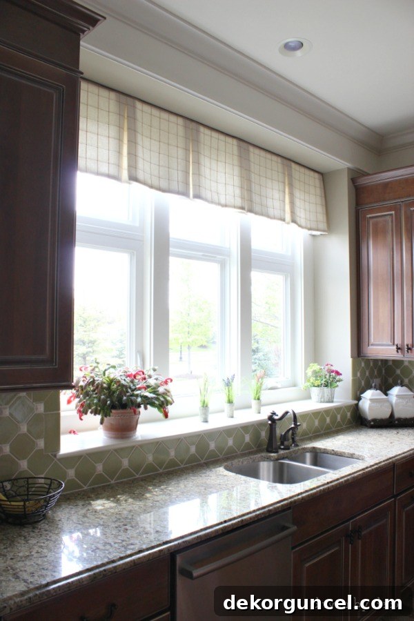 A simple, tailored valence decorates the long window above the kitchen sink, unifying the kitchen's aesthetic with the family room.