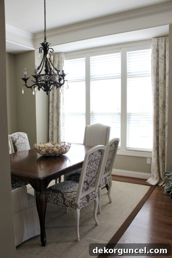 Dining room with windows extending to the corners, illustrating how standard drapes would block light due to lack of stacking space.