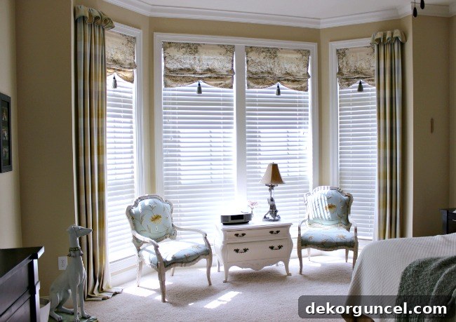 Unique and elegant window treatments in a master bedroom featuring a large bay window, combining faux shades and drapes.