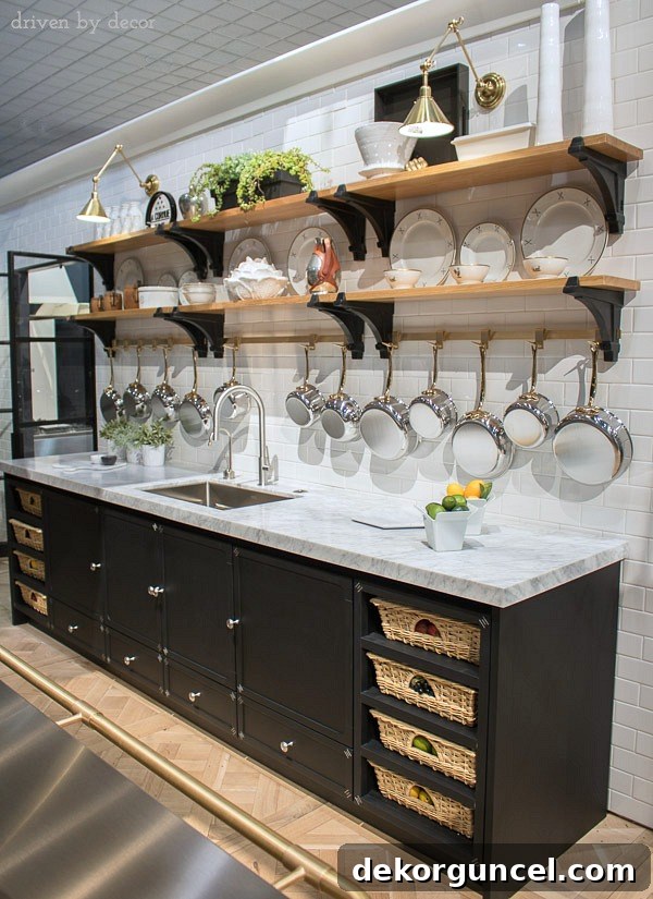 Fabulous La Cornue kitchen with open shelving, brass pot rack, swing-arm sconces, and cabinets with pull-out baskets