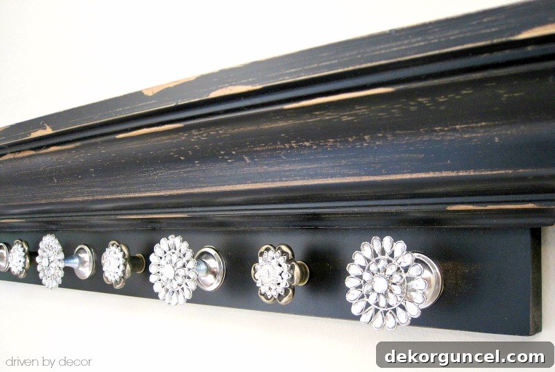 Rhinestone knobs elegantly adorn a wall-mounted ledge shelf, creating a dazzling awards medal display.