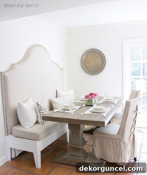 An upholstered banquette and pedestal table save space in a small eat-in area!
