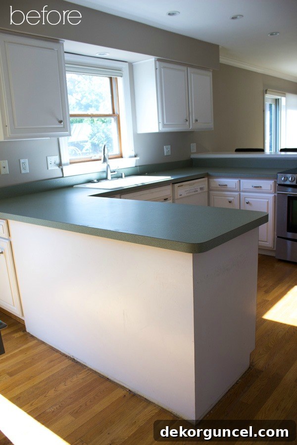 Before picture of the kitchen peninsula, showing its flat laminate back and recessed drawer before the decorative molding was added.
