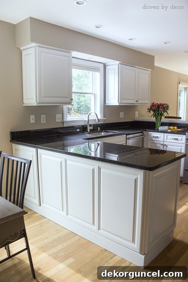 After picture of the kitchen peninsula featuring elegant decorative panels, new base molding, and a discreet push-to-open cabinet door.
