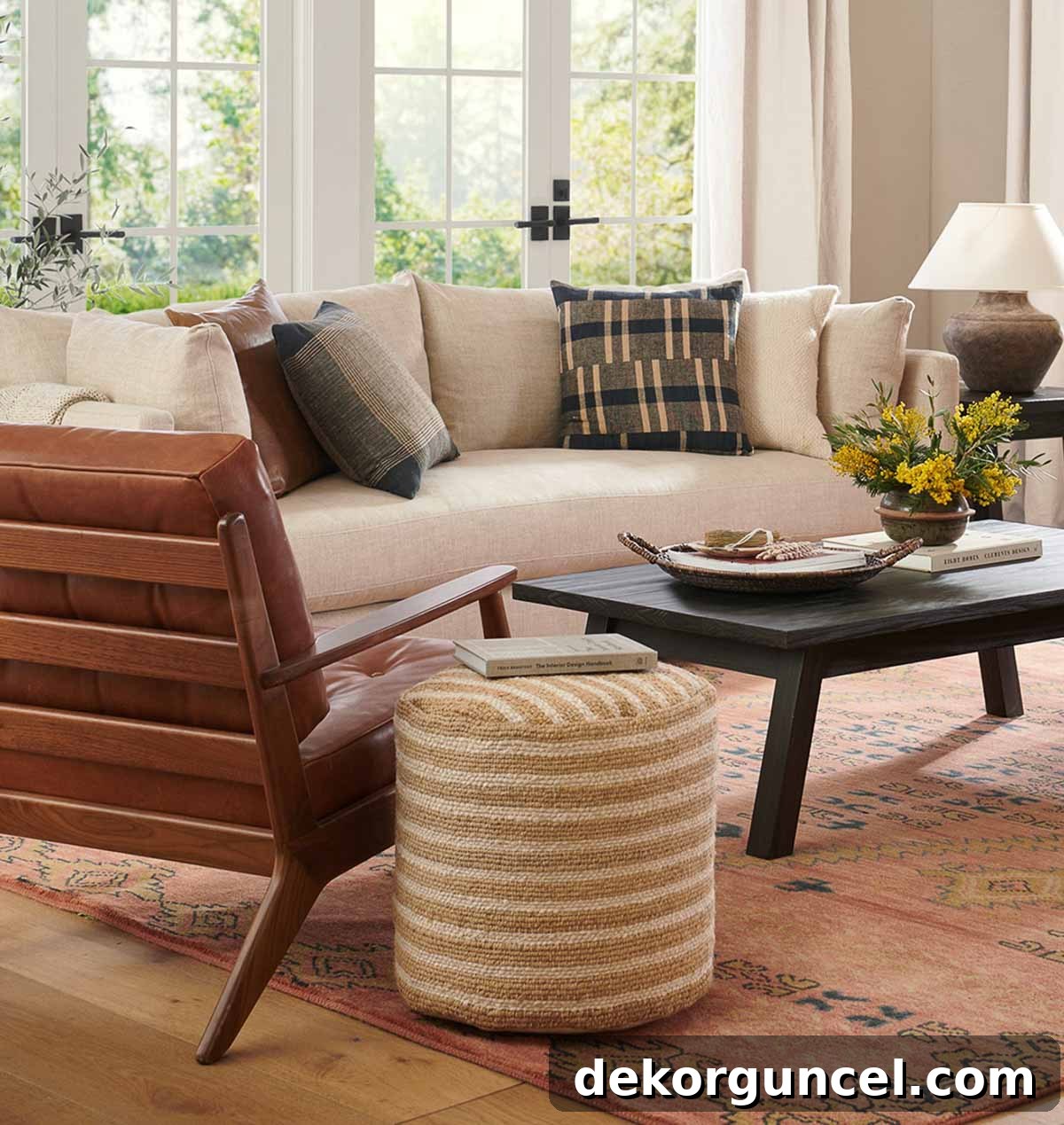Striped jute pouf cleverly utilized as a side table next to seating, showcasing creative decorating with poufs.