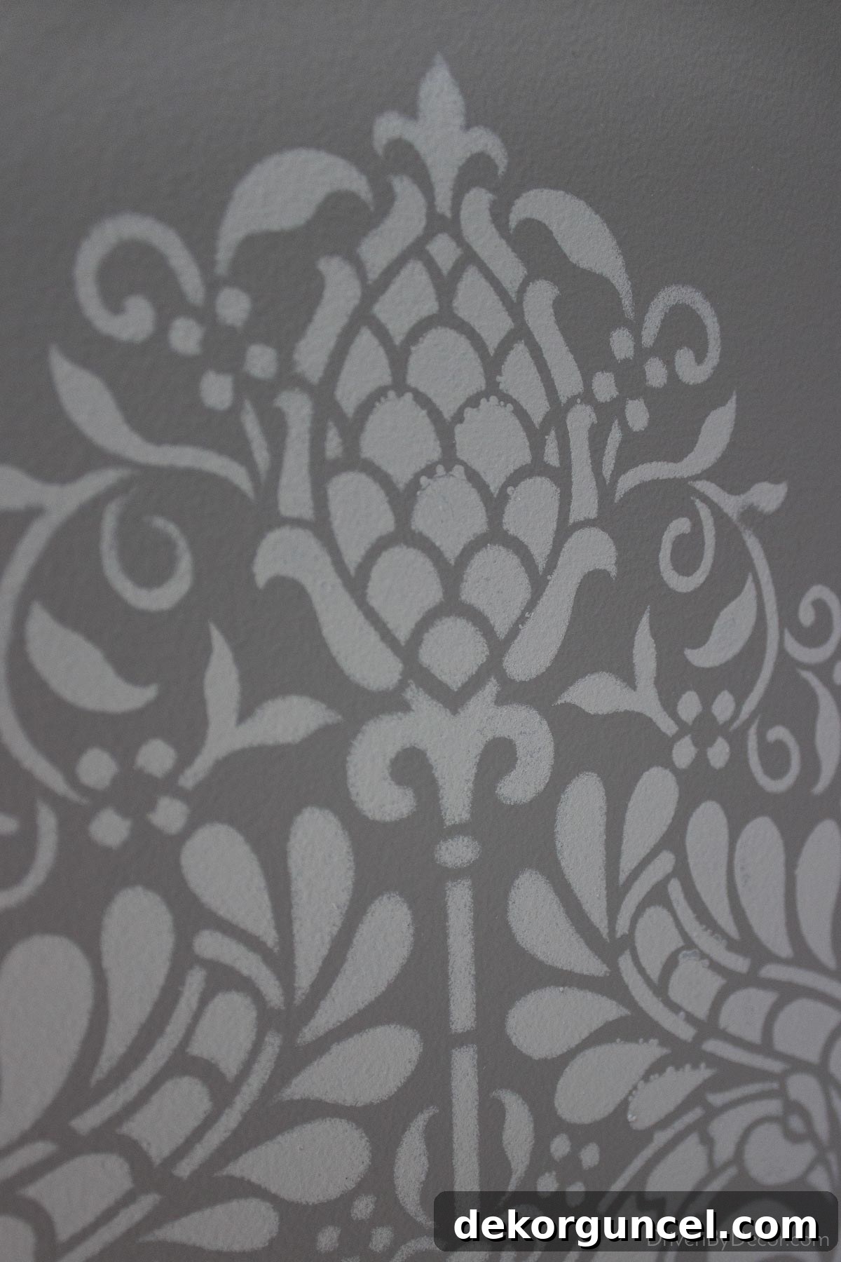 Şablonla Duvarlarınıza Hayat Verin: Büyüleyici Alanlar Yaratın 16 Close-up of minor imperfections in a wall stencil application, such as slight paint bleed, demonstrating that these small flaws are often invisible in the finished space.
