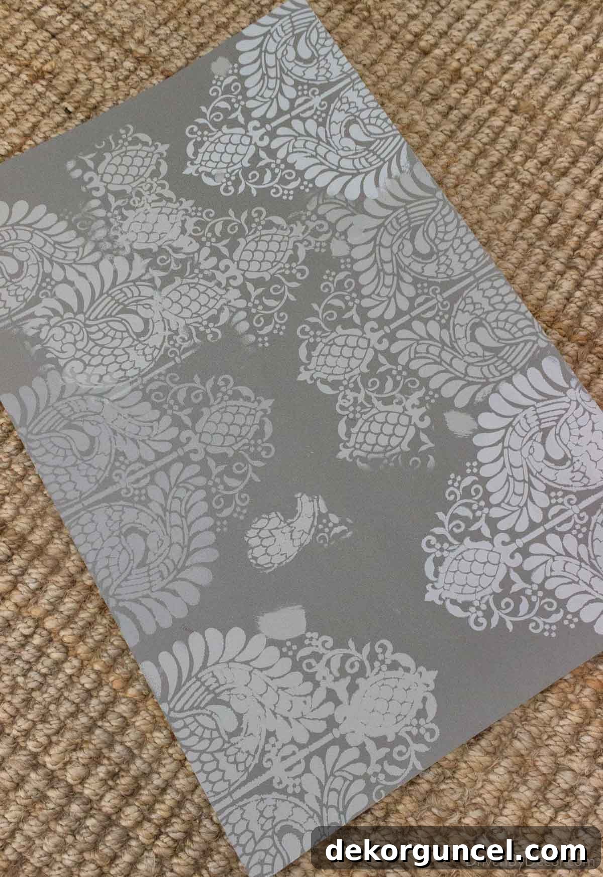 Şablonla Duvarlarınıza Hayat Verin: Büyüleyici Alanlar Yaratın 7 A foam board displaying early practice stenciling attempts, showing initial imperfections and gradual improvement in technique.