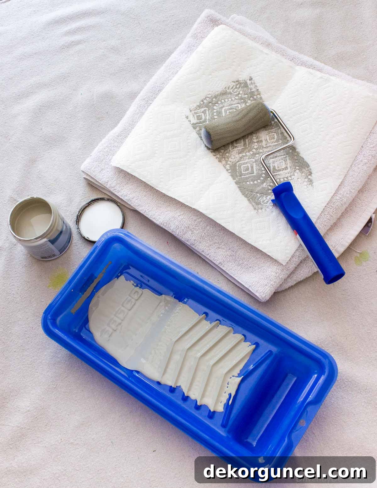 Şablonla Duvarlarınıza Hayat Verin: Büyüleyici Alanlar Yaratın 8 A foam roller being run over a stack of paper towels to remove excess paint, a crucial step for achieving clean and crisp stencil lines.