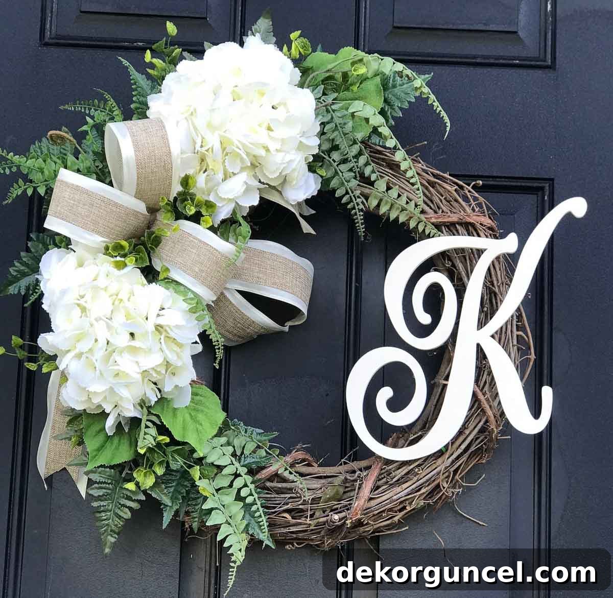 Decorative Letters: Top Sources and Creative Home Decor Ideas 10 An elegant wreath adorned with faux hydrangeas and ferns, featuring a central decorative letter for a personalized front door display.