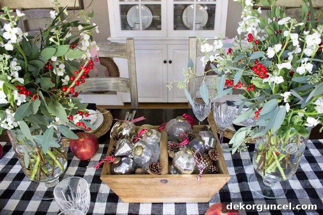 Quintessential New England Christmas Style 13 An inviting Christmas table centerpiece showcasing a collection of vintage ornaments thoughtfully arranged with natural pinecones, evoking a nostalgic holiday feel.