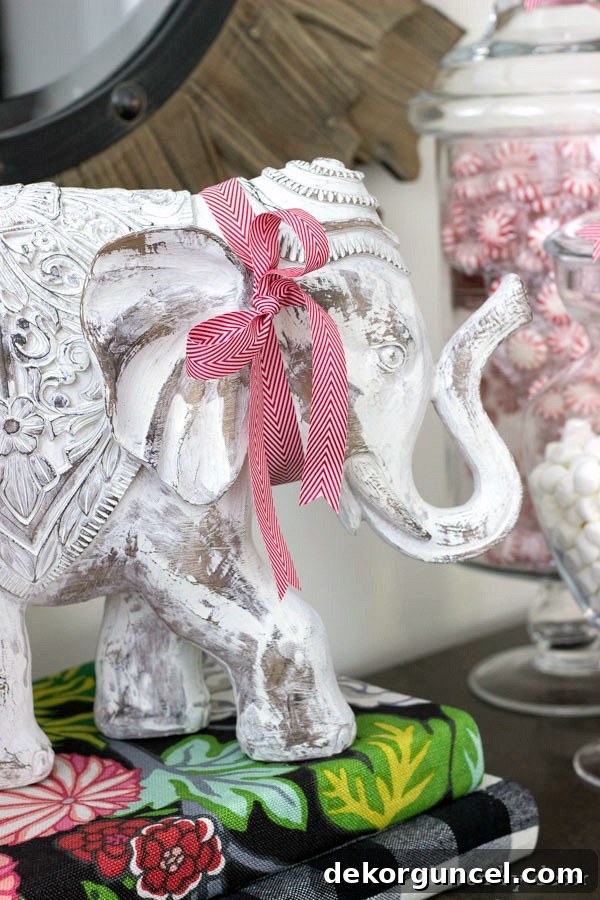 Quintessential New England Christmas Style 6 A delightful elephant figurine accessorized with a simple red and white herringbone bow, showcasing how easily everyday home accessories can be dressed up for the holiday season.