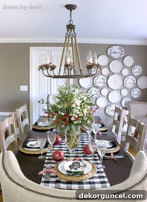 Quintessential New England Christmas Style 7 A beautifully decorated dining room for Christmas, showcasing a harmonious blend of black and white accents with vibrant green and red elements. The plate wall serves as a stunning focal point.