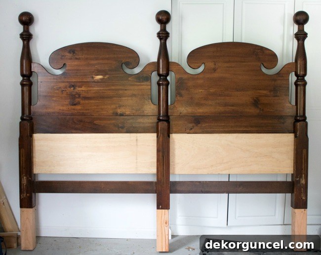 A Craigslist headboard stunningly transformed with a fresh coat of paint and expertly added height, showcasing a remarkable 'after' result that proves DIY potential.