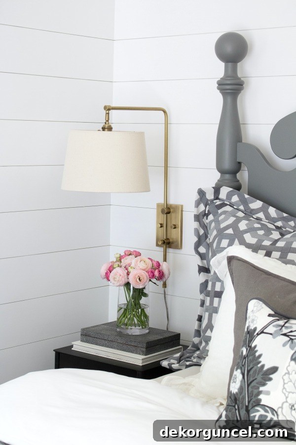 An elegant swing arm sconce, perfectly integrated into this master bedroom makeover, featuring a shade that swings and pivots for effortless reading in bed, combining style with practical functionality.