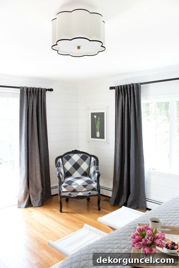 A stylish corner vignette featuring a fabulous flushmount light fixture overhead and an incredibly chic buffalo check chair, creating an inviting and well-designed space.