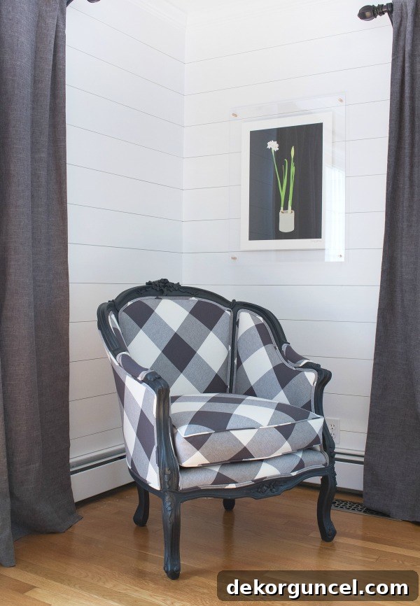 A cherished vintage chair beautifully painted and reupholstered in a striking oversized buffalo check fabric, artfully arranged on the diagonal, creating a truly beloved and unique design statement.