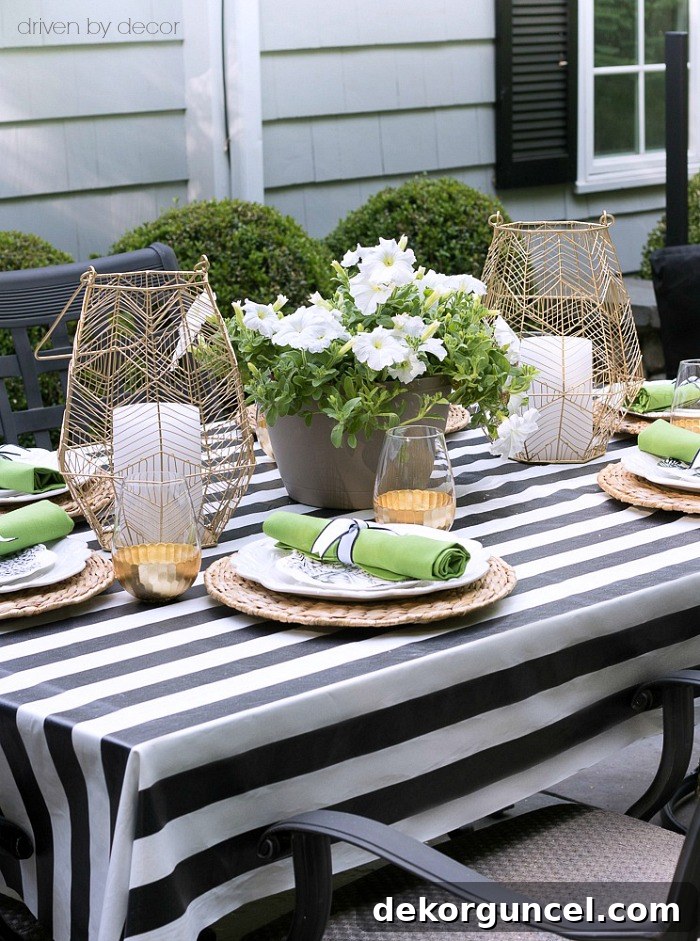 A pair of gold wire lanterns symmetrically placed beside a flower-filled planter, creating a beautiful outdoor table centerpiece.