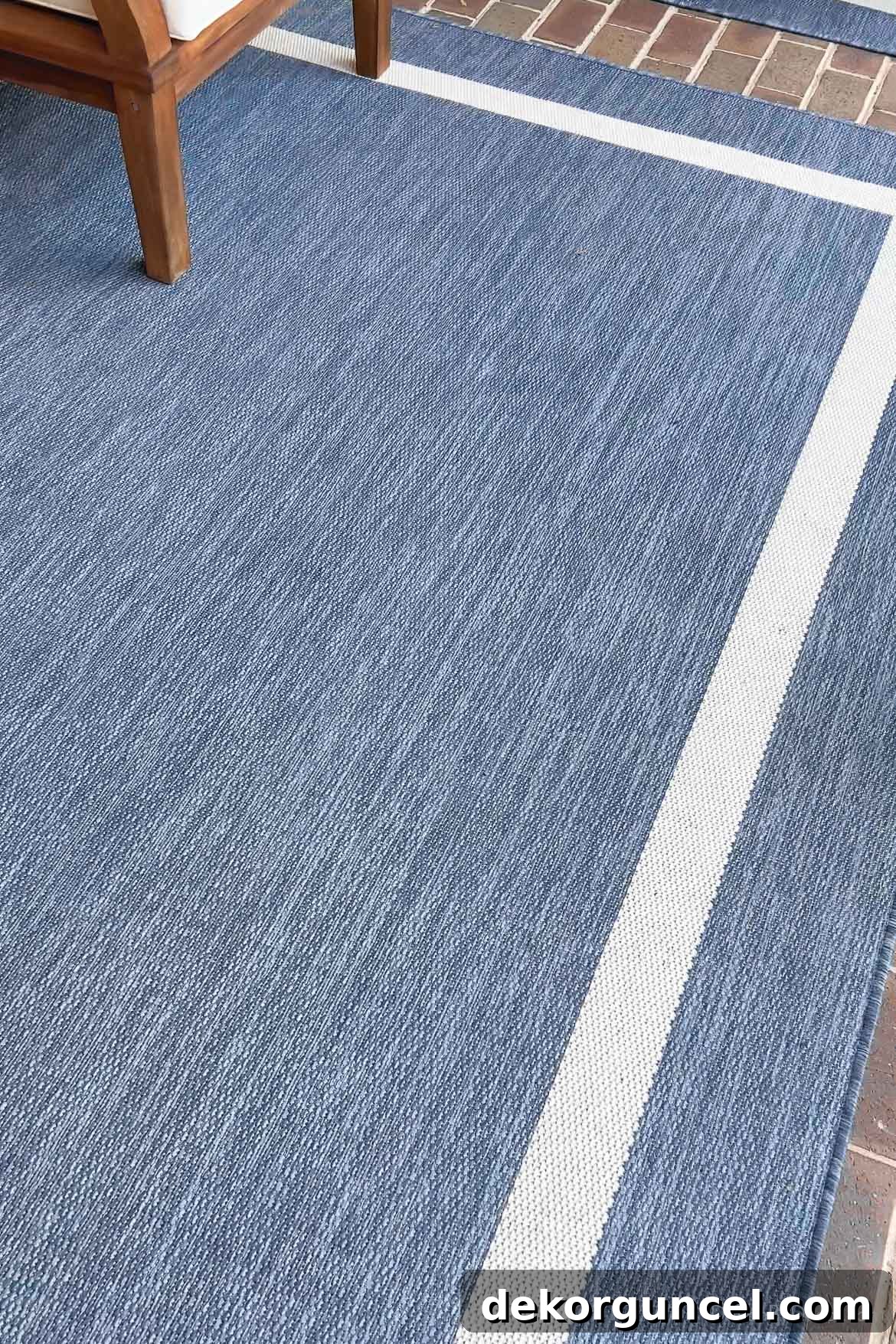 Elegant blue framed outdoor rug complementing the decor of a stylish porch, showcasing modern outdoor furniture.
