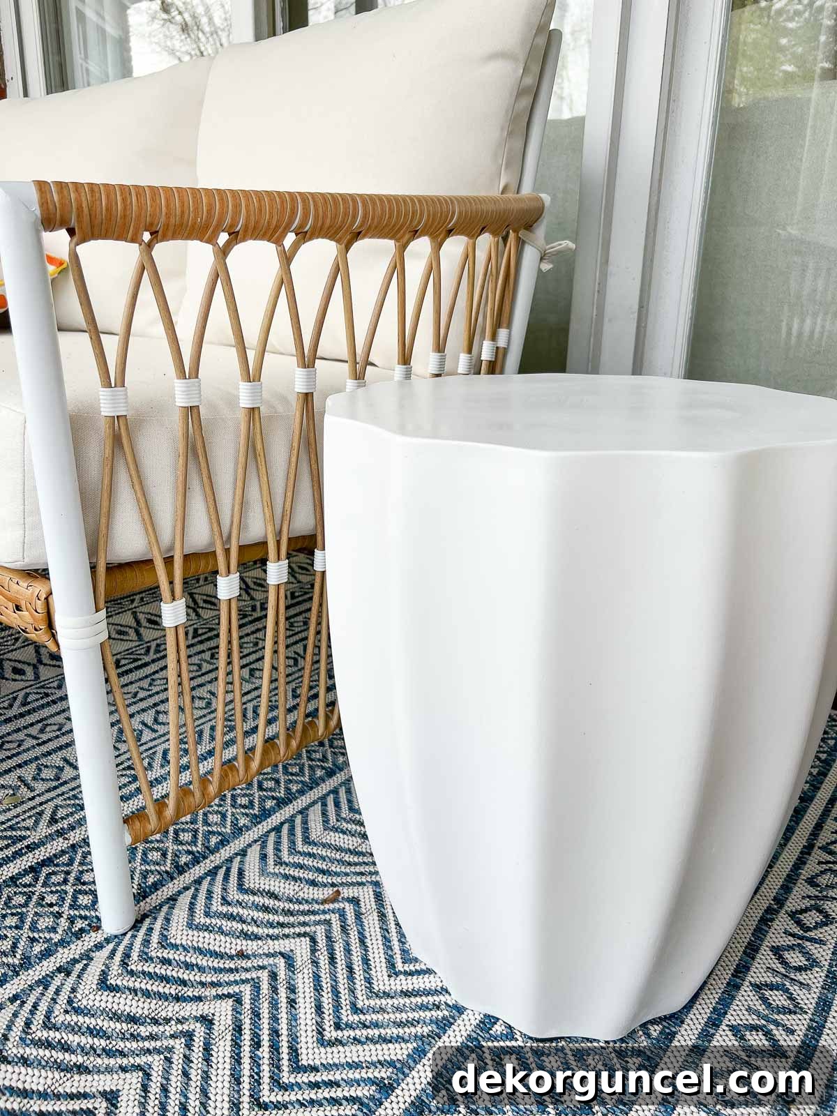 Stylish scalloped white concrete stool enhancing an outdoor living area, used as a functional and decorative accent.
