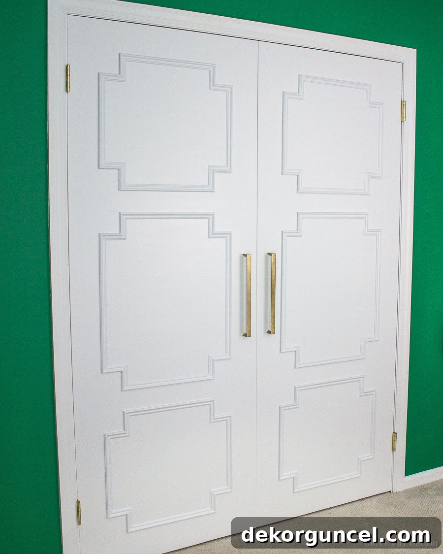 My Top 10 DIY Home Projects 20 After image of a closet door transformed with decorative molding pieces applied to its flat surface, creating a paneled look, with updated hardware, showcasing a successful DIY door makeover.
