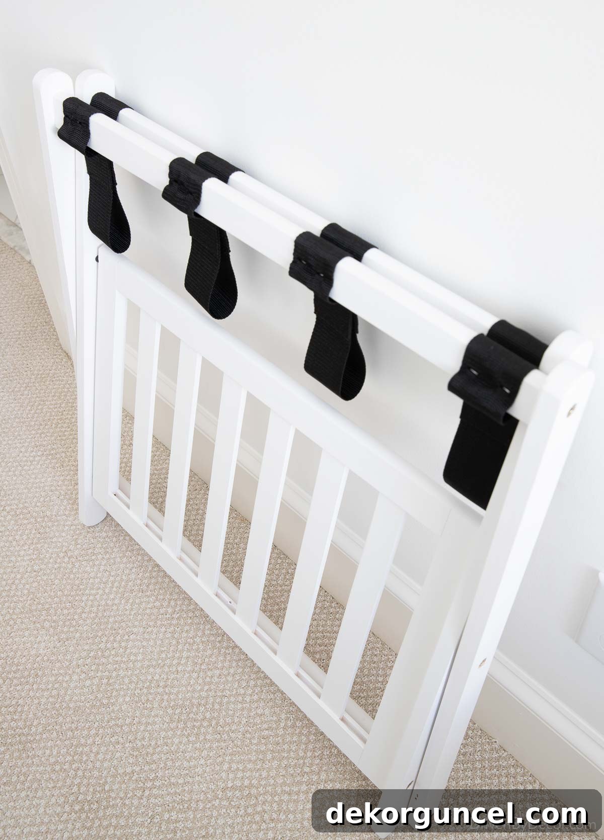 Space-saving white folding luggage rack for a modern guest bedroom
