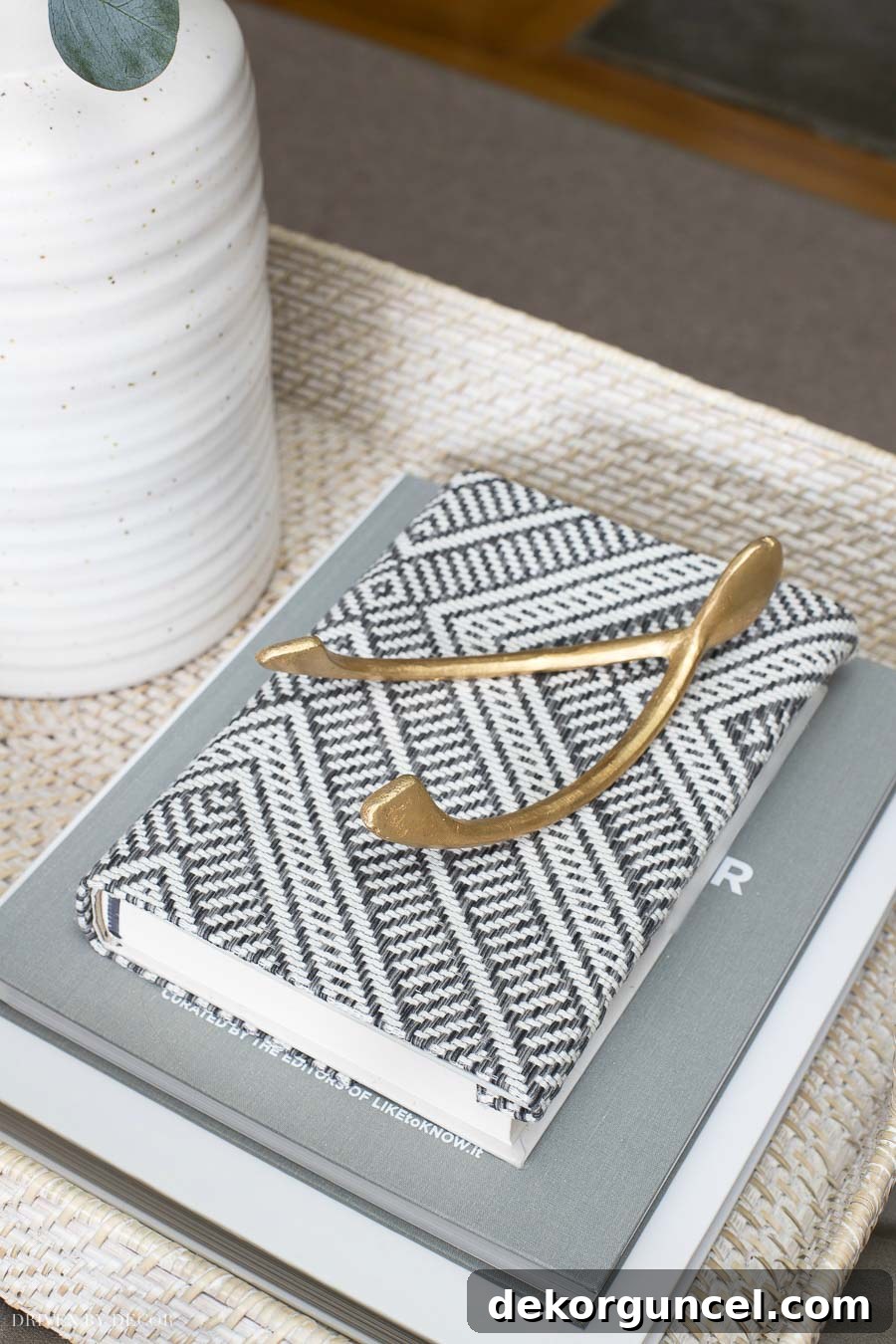 A fabric-covered book as part of coffee table decor, demonstrating a creative way to add color and texture.