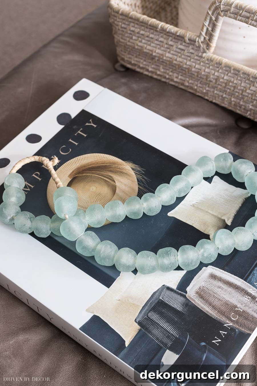 Elegant glass beads draped over books, serving as a stylish coffee table decor element.