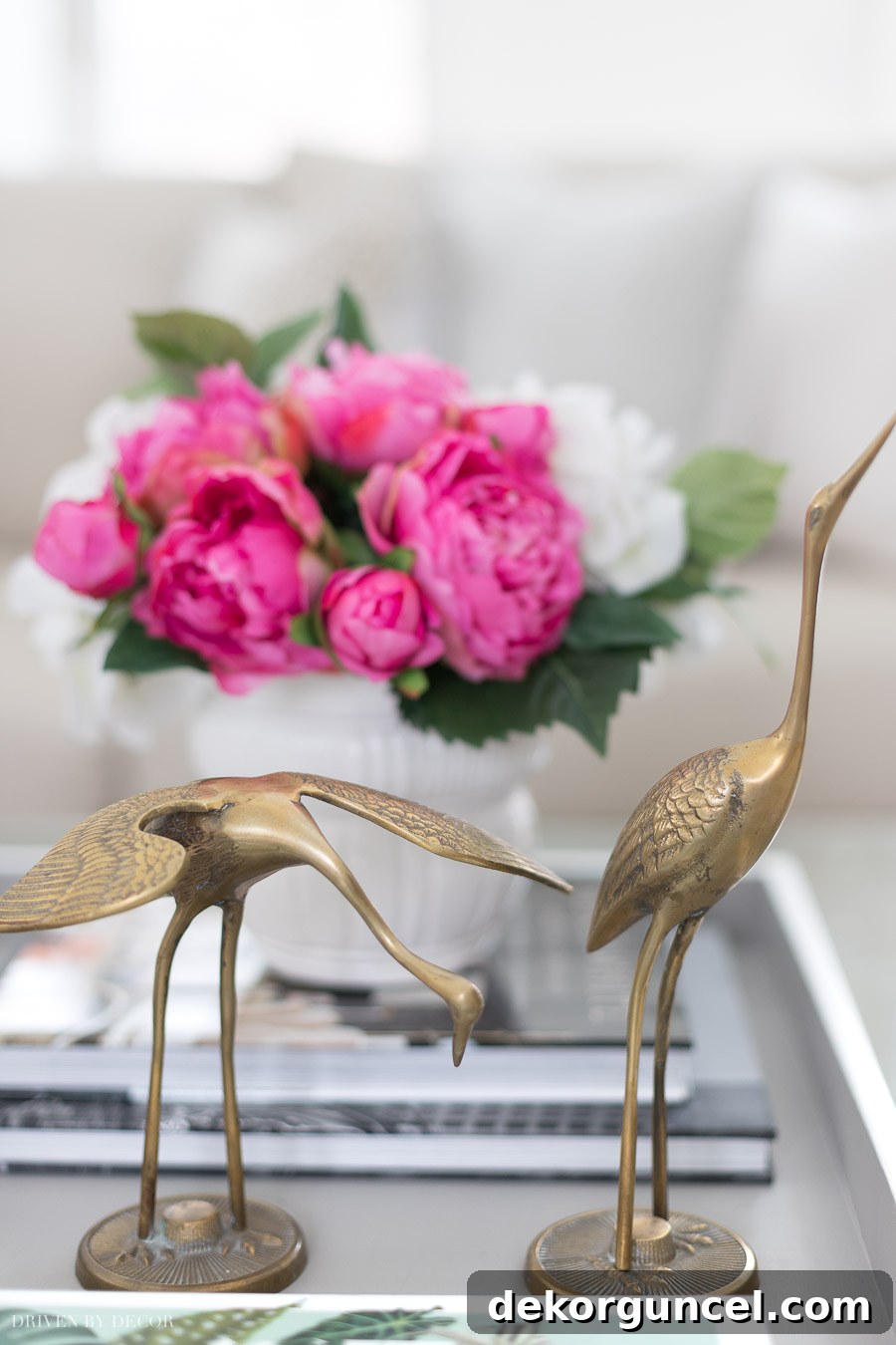 A pair of vintage brass cranes used as unique coffee table decor, adding a quirky touch to the styling.
