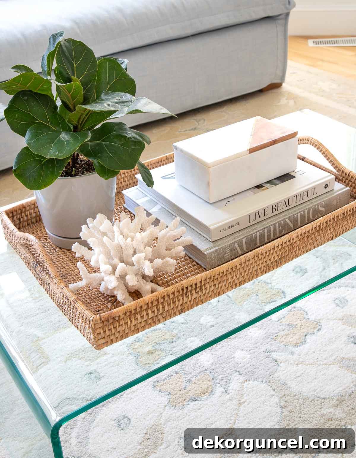 A woven tray neatly holding coffee table decor on a budget-friendly glass coffee table, illustrating practical styling.