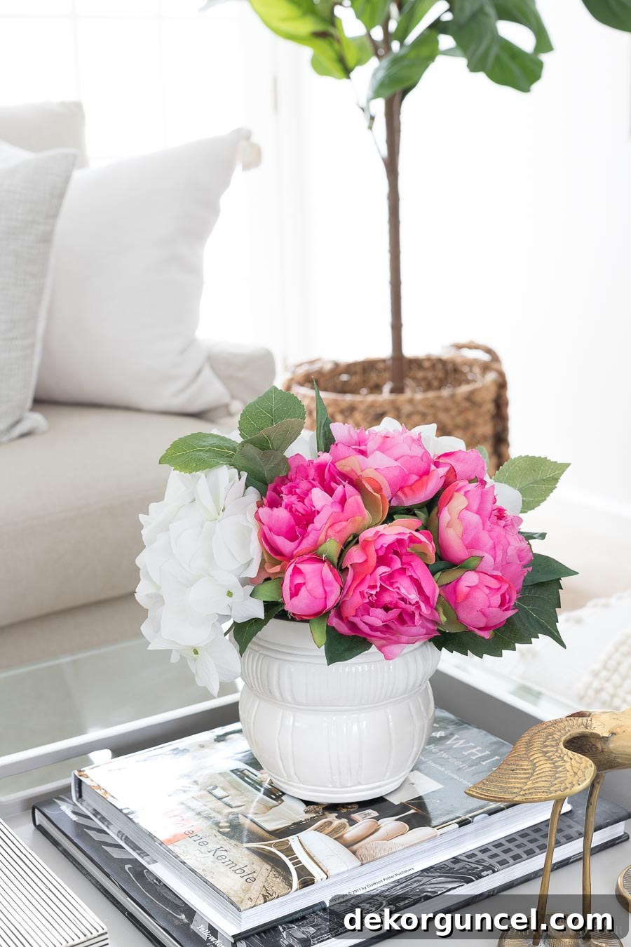 A beautiful arrangement of faux peonies and hydrangeas in a white planter, perfect for lasting coffee table decor.
