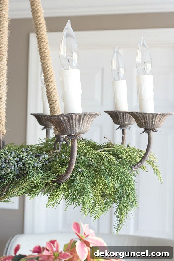 Christmas home tour - lay evergreen branches on the base of your chandelier for a simple, elegant Christmas table