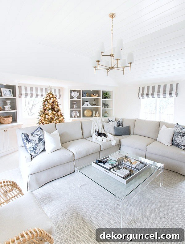 Christmas house tour of neutral living room with vaulted planked ceilings, a slipcovered sectional, acrylic coffee table, and more!