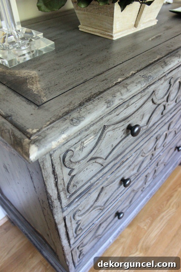 Our Foyer's Stunning Transformation 3 Close-up of a beautiful gray distressed wood chest of drawers showcasing antique finish and details