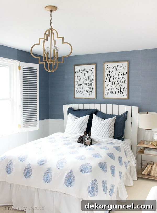 A classic white slatted headboard allows the grasscloth wallpaper and gorgeous blue and white bedding to shine!