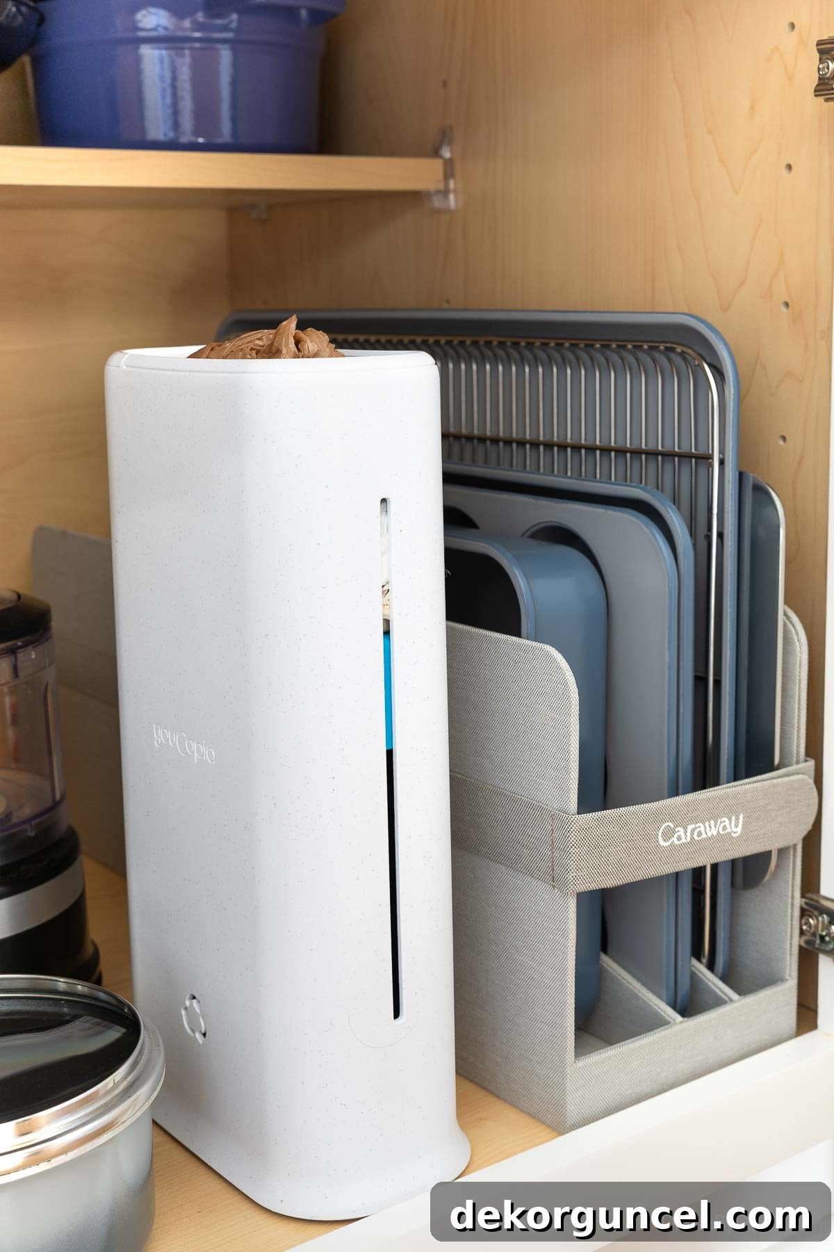 Organizing Under the Kitchen Sink: A Guide to a Tidy Space 16 White plastic bag dispenser inside a cabinet for kitchen organization.