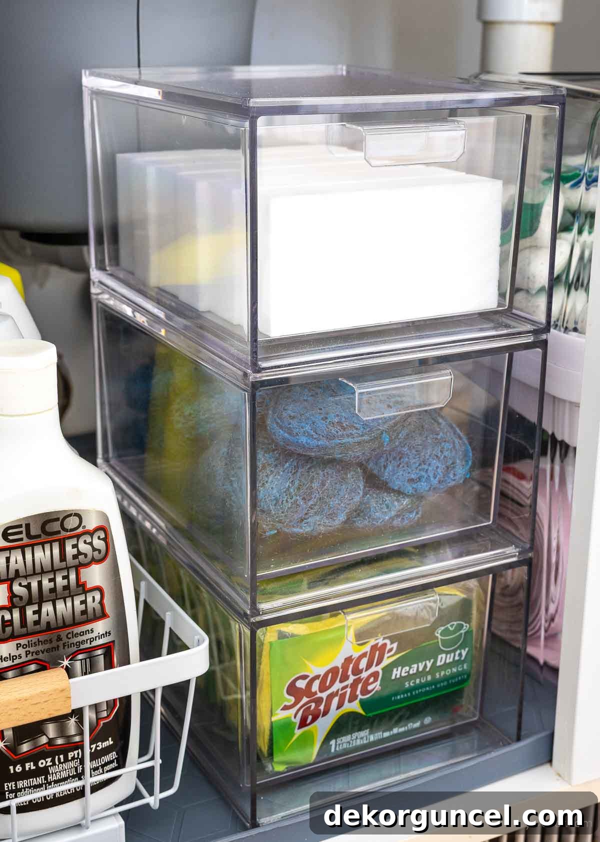 Organizing Under the Kitchen Sink: A Guide to a Tidy Space 17 Stackable acrylic drawers holding sponges and cleaning pads under the sink.
