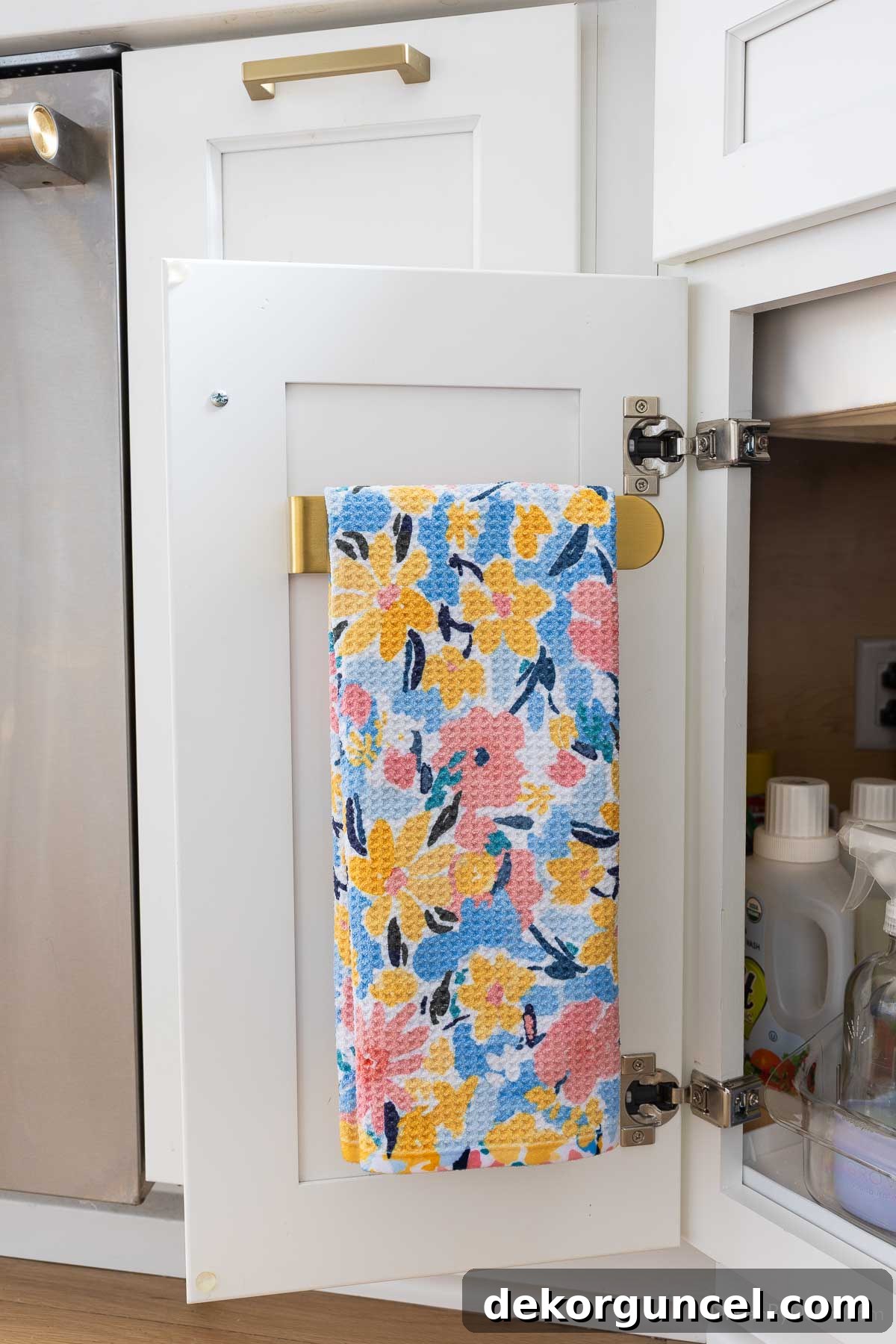 Organizing Under the Kitchen Sink: A Guide to a Tidy Space 20 Dish towel hung on a holder on the inside of a cabinet door.