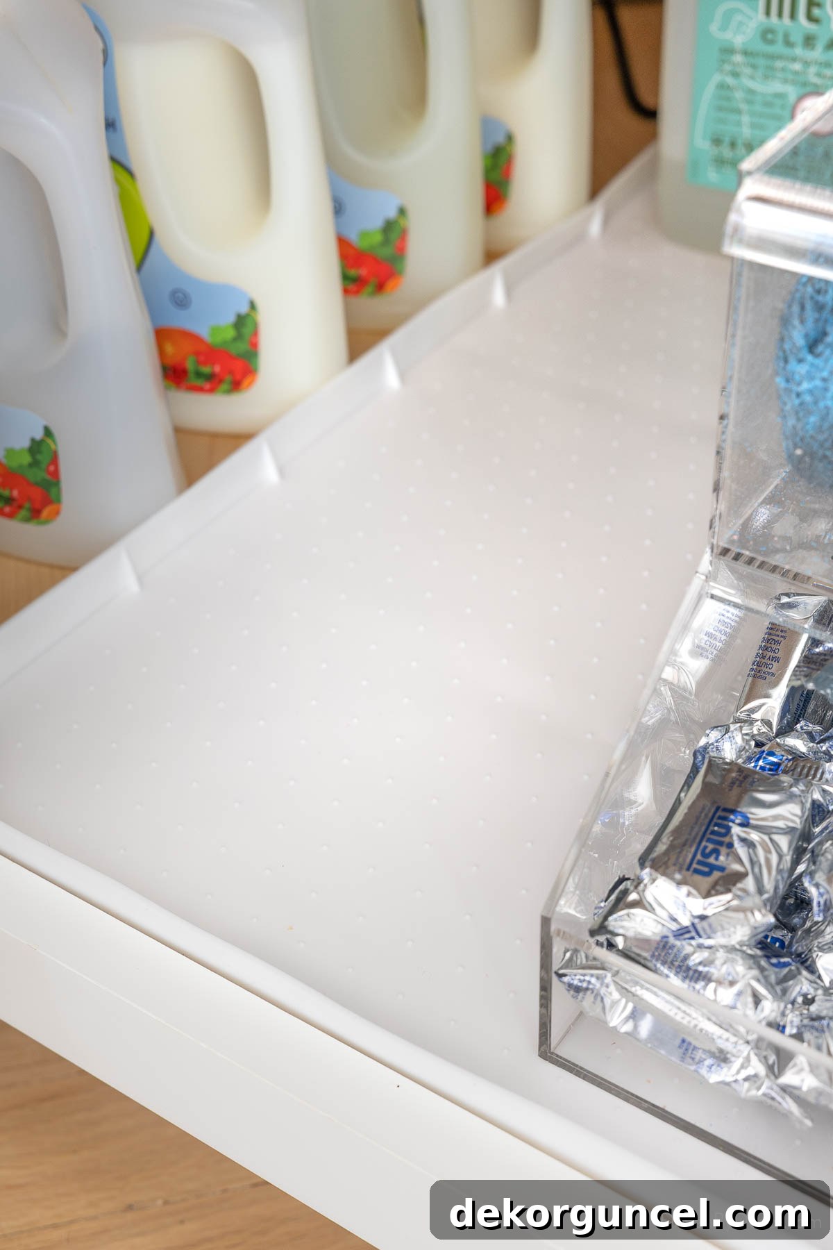 Organizing Under the Kitchen Sink: A Guide to a Tidy Space 4 A white waterproof cabinet liner installed under a kitchen sink.