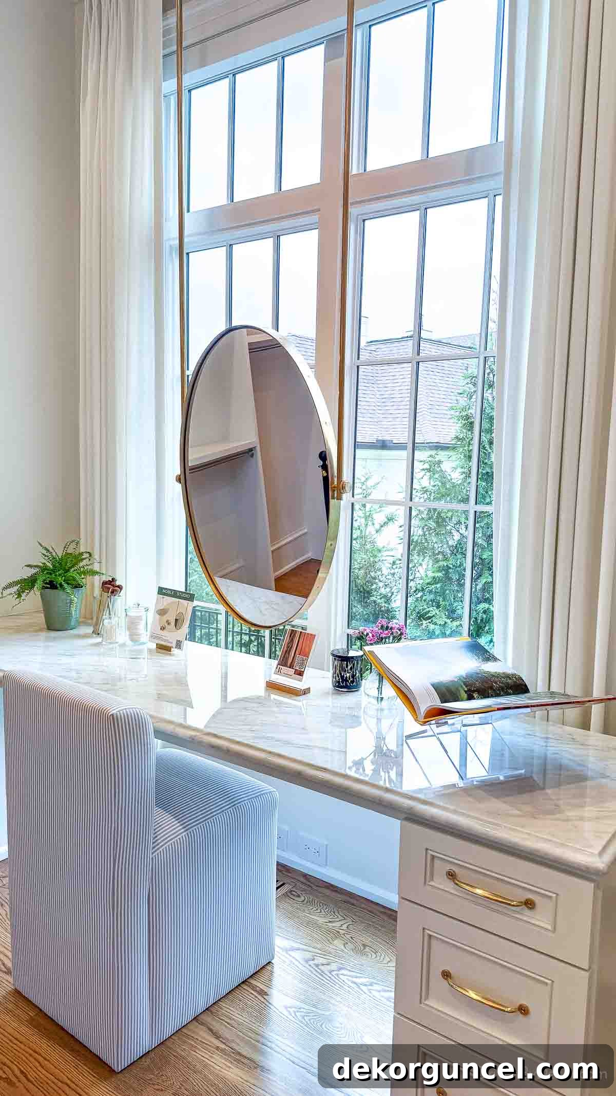 Inspirational image of a sit-down vanity with a mirror positioned in front of a window within a master closet